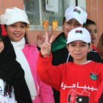 Meninas com a bandeira da líbia estampada com o gesto que simboliza a expressão Libya – Trípoli