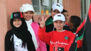 Meninas com a bandeira da líbia estampada com o gesto que simboliza a expressão Libya - Trípoli