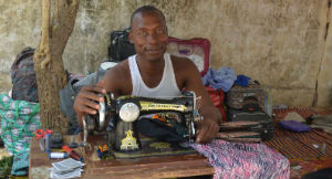 Moussa com a máquina de costura que lhe foi emprestada. Ele usará a máquina para ganhar algum dinheiro extra e retomar seus estudos em Direito no Chade. Foto: ACNUR/M. Farman-Farmaian