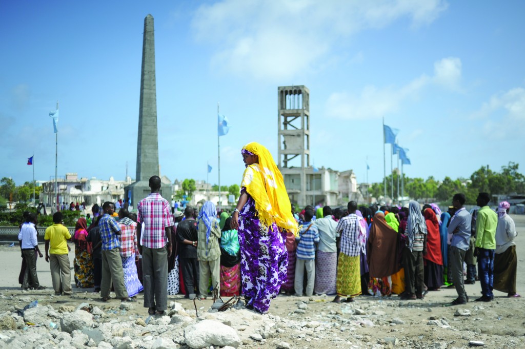 A woman stands in front of a crowd of people watching a group of dancers perform in Mogadishu, Somalia, on August 8. Somalia today enjoyed a peaceful Eid-Ul-Fitr, one of the most important dates on the Muslim calendar. Thousands dressed up and came out onto the streets to enjoy the holiday. AU UN IST PHOTO / TOBIN JONES