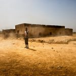 A young boy stands on the road as the winds and sand pick up in the suburbs of Kaédi, Mauritania. Photo: WFP/Agron Dragaj